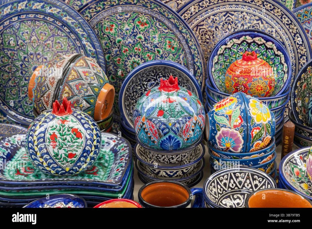 Tourists taking part in a hands-on Gijduvan pottery workshop in Samarkand, learning pottery making from a local Uzbek artisan
