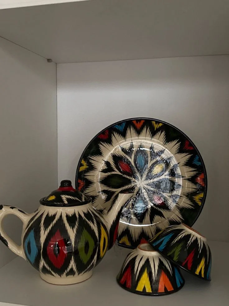 Uzbek miniature painting artist working in a traditional workshop in Bukhara, creating detailed Silk Road illustrations by hand