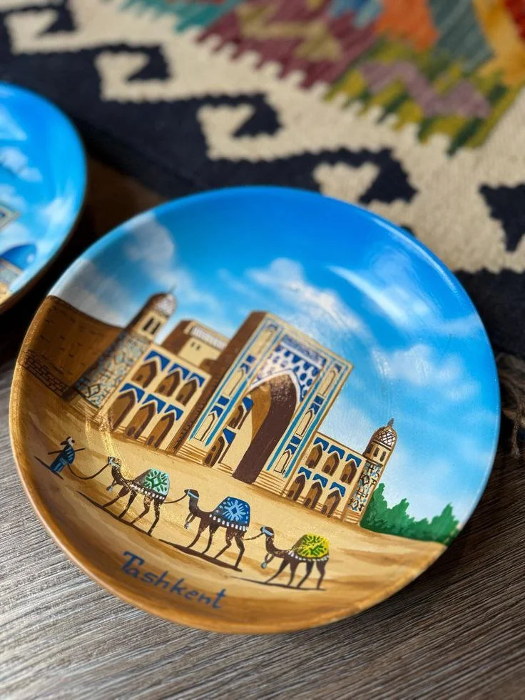 Traditional Uzbek miniature paintings and Gijduvan ceramics displayed over blue Samarkand tile patterns, representing Silk Road visual arts